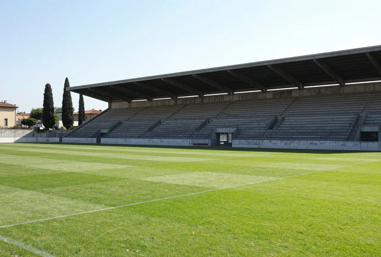 Alte italienische Stadionkurve aus Beton mit verblichener Farbe im Nachmittagslicht, dahinter Zypressen