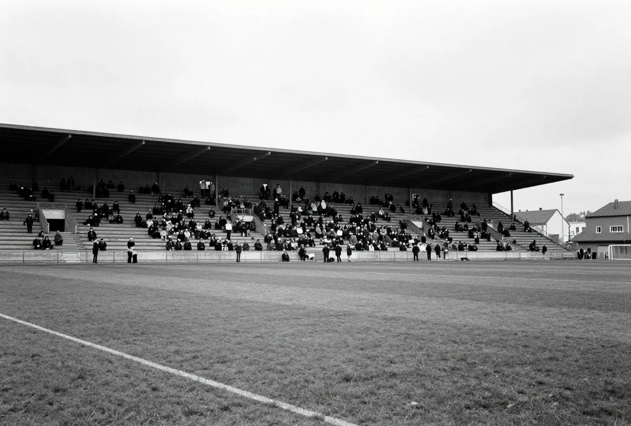 Stadion der 1950er Jahre mit steilen Erdwällen voller Zuschauer in Hüten, von weitem im Schwarzweißstil