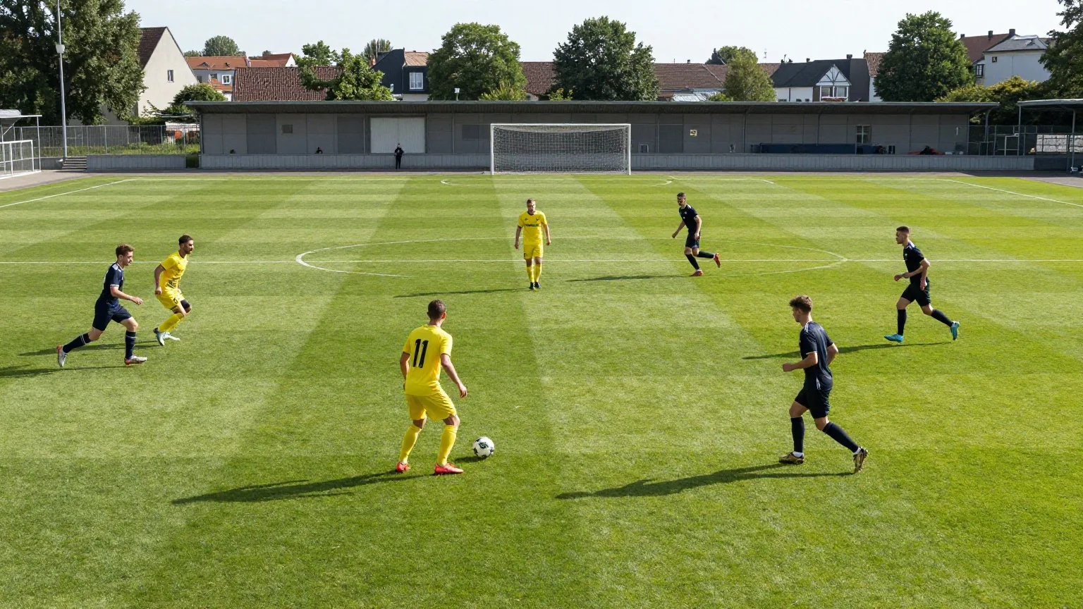 Spieler in gelben Trikots stehen im Dreieck verteilt und passen sich den Ball flach zu